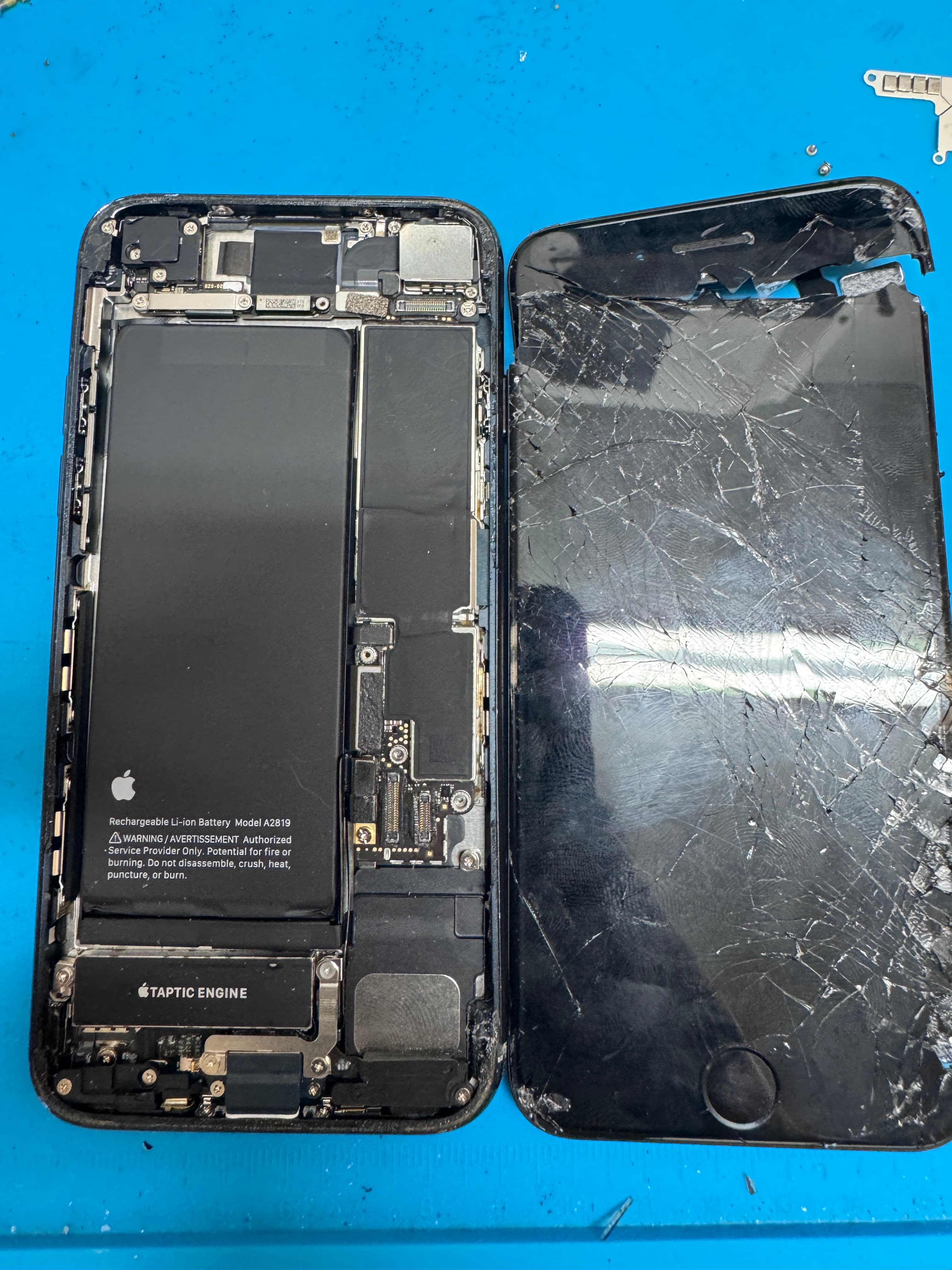 Shattered iPhone display lifted off the chassis on the KINGSELL bench