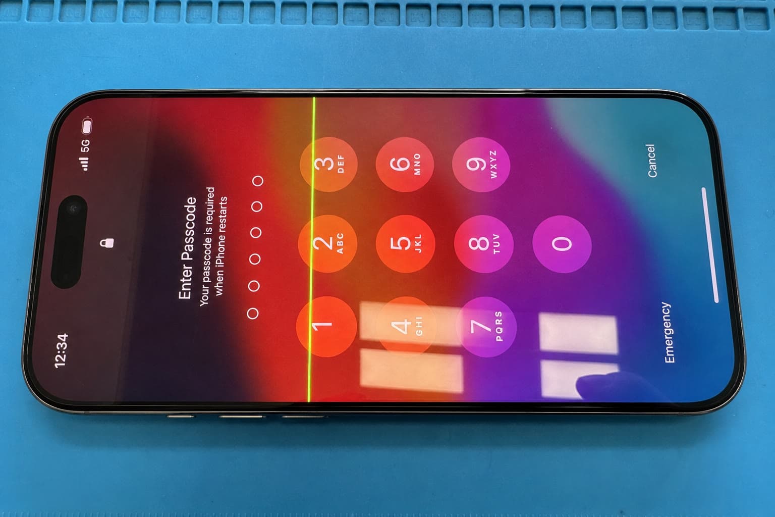iPhone 16 Pro on the bench with a green line through the passcode screen